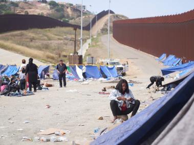 Migrante espera entre las dos vallas fronterizas en la frontera sur de EE.UU. con México en San Diego.