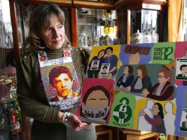 Rosalba Campos Guevara sostiene un bordado y varios cuadros en los que se recuerda el caso del Colectivo 82.