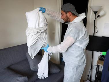NYT: Un técnico en biocidas retira fundas de almohadas para evitar la propagación de ácaros en un departamento cerca de París el mes pasado.