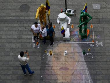 En las calles de Medellín , un artista callejero pinta la imagen de la cantante Karol G.