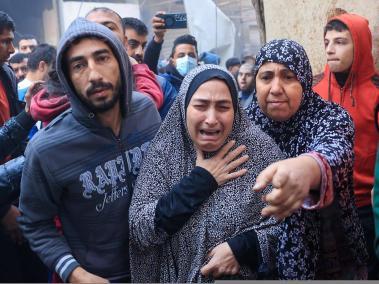 Una mujer palestina llora mientras transportan a los heridos en una ambulancia tras los ataques aéreos israelíes.