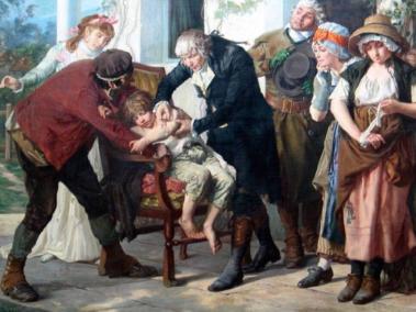 Representa a Edward Jenner, médico inglés descubridor de la vacuna contra la viruela, haciendo la primera inoculación a un niño en 1796. El mismo proceso fue replicado 7 años después por la Real Expedición Filantrópica de la Vacuna en América.