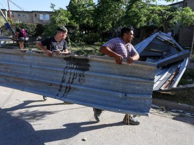 Vecinos de un barrio de escasos recursos reparan los daños causados por un temporal en Bahía Blanca.