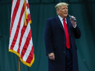 El expresidente Donald Trump habla con los votantes durante una visita a un sitio de caucus en Clive, Iowa.