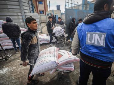 Palestinos desplazados reciben ayuda alimentaria en centros de Naciones Unidas en Rafah.