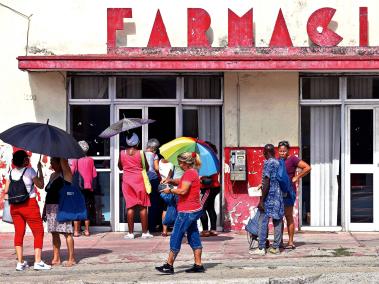 Mujeres en La Habana esperan afuera de una farmacia para conseguir toallas higiénicas, un producto que se ha encarecido.