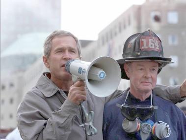 El presidente estadounidense George W. Bush junto al bombero retirado Bob Beckwith, de 69 años, mientras examina los daños en el sitio del World Trade Center