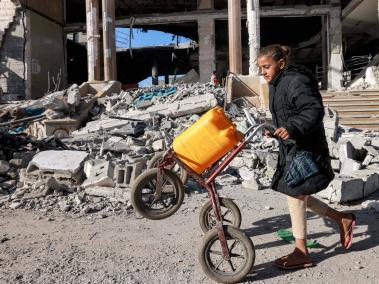 Una niña camina junto a los escombros de un edificio destruido durante un bombardeo israelí en Rafah.