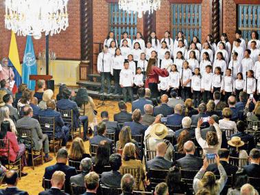 Diplomáticos de 15 países posan con los niños del coro Hijas e Hijos de la Paz, tras su presentación en la Cancillería colombiana, el 8 de febrero.