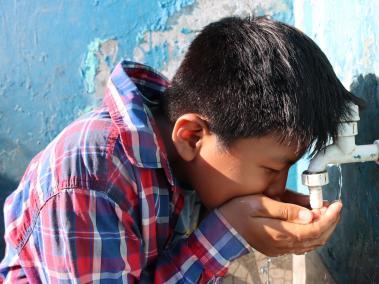 Un niño de la comunidad Puerto Yumani bebe el agua que sale de un grifo. El recurso llega a los hogares gracias al trabajo de los comuneros.