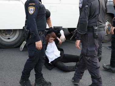 Agentes israelíes desaloja a un judío ultraortodoxo que protestaba contra el fin de la exención del servicio militar para esa comunidad.