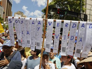 Un ciudadano sostiene reproducciones de actas electorales en una manifestación este sábado, en Caracas (Venezuela).