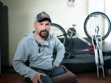 Jesús Mejía Corredor en la sala de su casa junto a su bicicleta.
