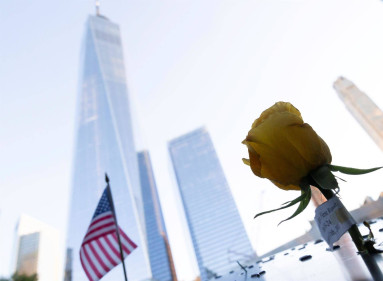 Una flor y una bandera ubicados en la piscina sur del "9/11 National Memorial", el monumento ubicado en los cimientos de las Torres Gemelas destruidas por los atentados del 11 de septiembre en Nueva York.