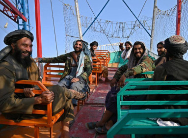 En esta fotografía tomada el 28 de septiembre de 2021, los combatientes talibanes disfrutan de un paseo en una atracción de barco pirata en un recinto ferial en el lago Qargha, en las afueras de Kabul.