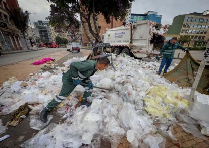 Funcionarios de la UAESP recogen una gran cantidad de basura dejada frente a la estación de Transmilenio de la Jiménez,  en el centro de la ciudad.