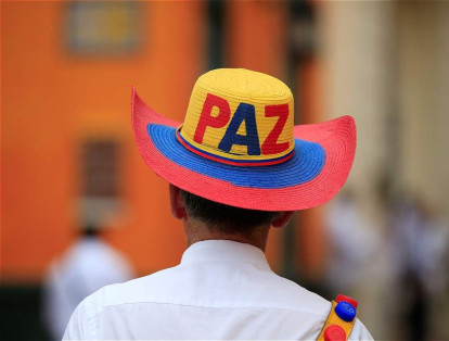 Un hombre camina con un sombrero de 'Paz' por las calles de Cartagena.