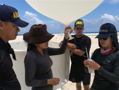 Johanna Yepes y Lizeth Puerres, de la Universidad Nacional sede Medellín, y los infantes de marina Juan Carlos Briñez y John Calvo, a punto de lanzar un globo meteorológico.