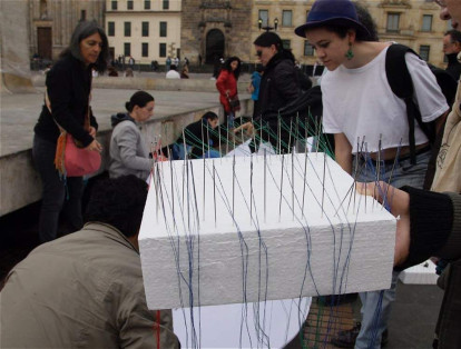 Los voluntarios cosen las piezas de tela para obtener los siete mil metros que cubran el lugar.