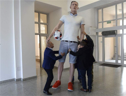 Trabajadores del Instituto de Diseño en Kilece, Polonia, cargan con la que ellos creen que es la figura más alta del mundo impresa en 3D.  La figura muestra al futbolista polaco Robert Lewandowski.
