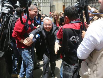 El expresidente Uribe fue asediado por ciudadanos y medios de comunicación, por lo que tuvo que apartarse con sus brazos.