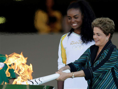 Dilma Rousseff (antes de su suspensión) con la llama olímpica junto a Fabiana Claudino, capitán del equipo de voleibol de Brasil, durante el paso de la antorcha por Brasilia.