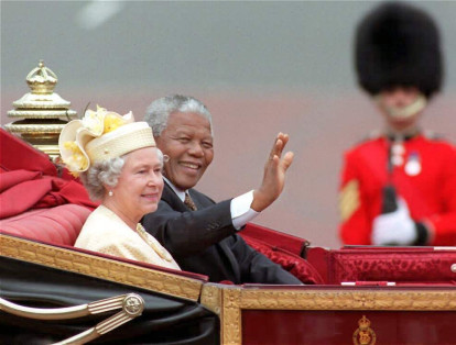 El presidente de Sudáfrica Nelson Mandela y la Reina Isabel II, avanzan hacia el Palacio de Buckingham, durante la primera visita oficial del mandatario africano a Londres, el 9 de julio del 2004.