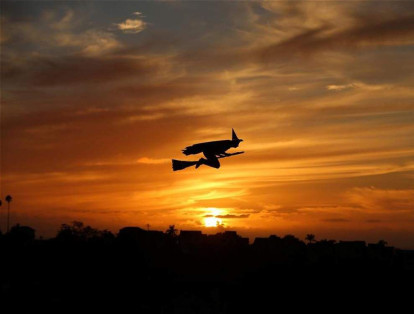 Un avión a control remoto y con forma de bruja sobrevuela durante el atardecer en Halloween de este año en Encinitas, California, Estados Unidos.