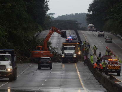Trabajadores municipales eliminan el fango y ramas de árboles después de que Otto golpeara la zona con fuertes lluvias en ciudad de Panamá.