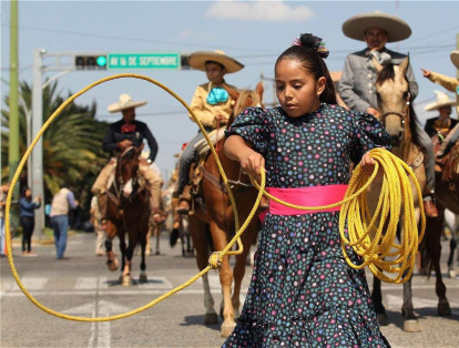 Durante la celebración del aniversario número 206 de la Independencia de México, una niña realiza suertes con la reata, actividad típica del país.