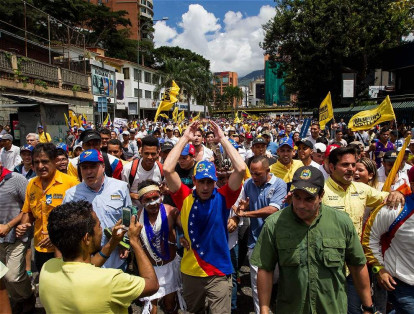 El líder opositor venezolano Henrique Capriles (c) junto a un grupo de personas que participa en la 'Toma de Caracas'.