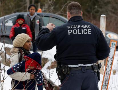 Luego de largas jornadas de viaje, familias enteras de inmigrantes se encuentran con la policía fronteriza de Canadá.