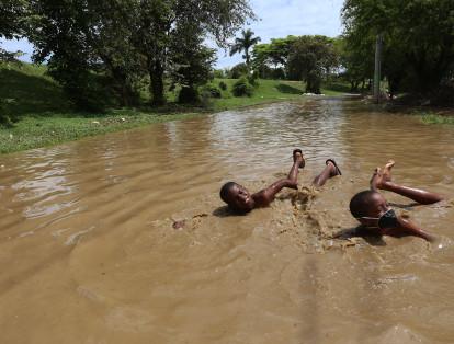 En el oriente, los niños aprovecharon la inundación de una calle para divertirse.