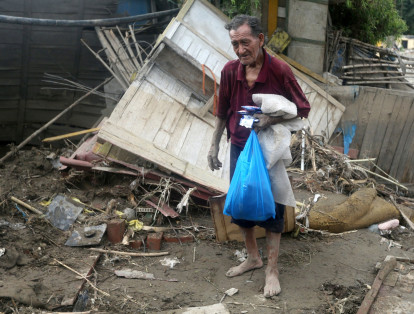 Un sobreviviente rescata algunas de sus pertenencias tras las fuertes lluvias que causaron destrucción en Huachipa.