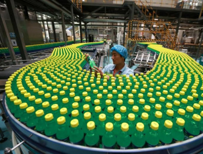 Las líneas de producción que parecen interminables son un común en el gigante asiático. En la foto un hombre revisa las botellas de una bebida gaseosa en la fábrica Luohe en la provincia de Henan.