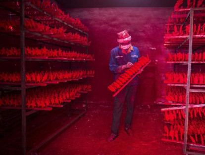 Una característica de estas fábricas es su alta producción en masa de las ventas. En la imagen un hombre revisa decoraciones de navidad en una empresa de Yiwu en la provincia Zhejiang.