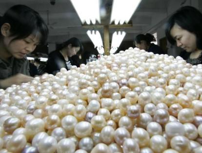 Empresas dedicadas a la fabricación de elementos poco usuales también se ven. En la foto algunas mujeres seleccionan perlas naturales cultivadas artificialmente.