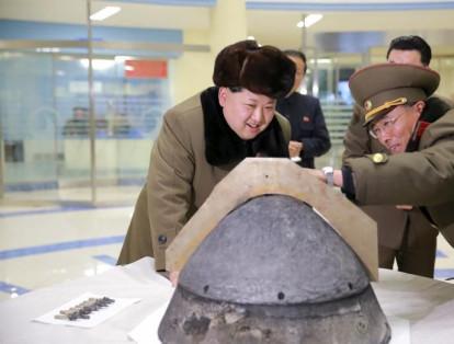 Kim Jong Un examina la punta de una ojiva de un proyectil después de una prueba simulada en un lugar no identificado.