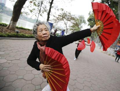 Una mujer practica un baile con abanicos junto al lago Hoan Kiem en Hanoi (Vietnam). En Asía, el número de personas mayores de 60 años en áreas urbanas en 2015 fue más del doble que en el 2000.