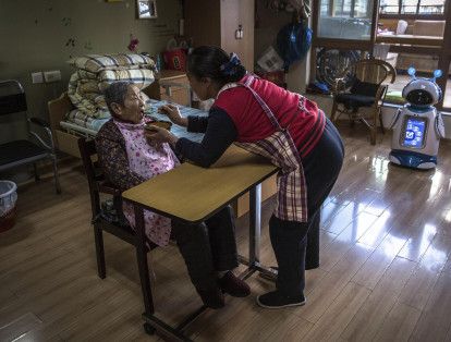 Una enfermera alimenta a una anciana en un centro social en Hangzhou en la provincia de Zhejiang (China).