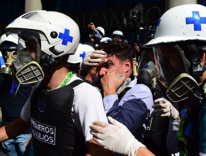 Un manifestante herido es llevado por voluntarios para prestarle atención médica.