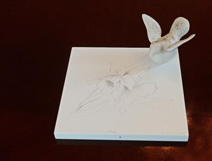 Es una paloma hecha a mano en porcelana blanca y en sus alas están dibujadas en grafito orquídeas y flores colombianas como la Cattleya o la Passiflora.