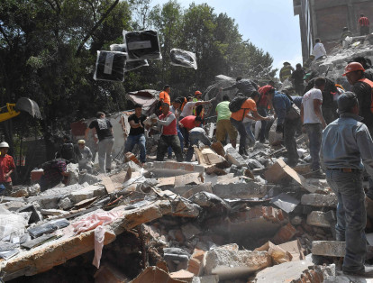 Personas remueven escombros en busca de víctimas tras el colapso de un edificio en Ciudad de México.