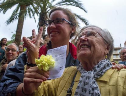 Una mujer muestra su papeleta para el referéndum independentisa del 1-O en Cataluña
