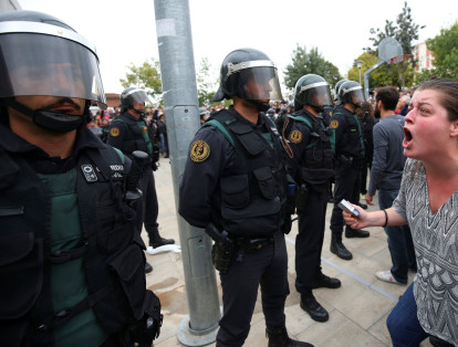 Una mujer increpa a un policía durante la jornada del referendo en Cataluña.