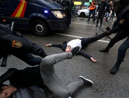 Guardias retiran a algunos manifestantes en Cataluña.