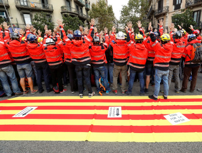 Bomberos sostienen sus manos durante una manifestación convocada para protestar contra acciones policiales durante el referéndum de independencia prohibido en
Barcelona,