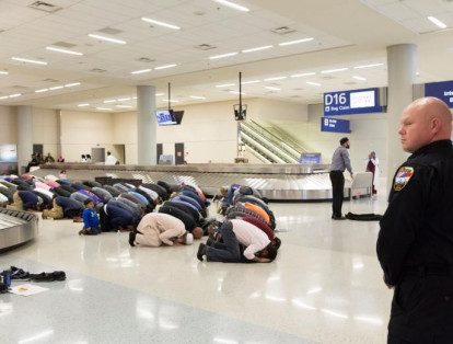 Personas se reúnen para rezar durante una protesta contra la prohibición de viajar impuesta por la orden ejecutiva del presidente estadounidense Donald Trump, en el Aeropuerto Internacional Dallas, Texas, el 29 de enero.