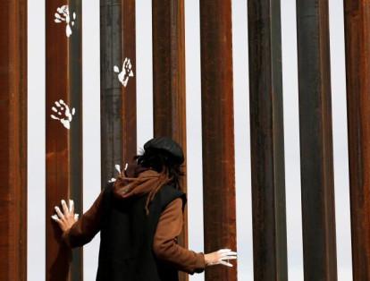 Un activista pinta el muro fronterizo entre Estados Unidos y México entre Ciudad Juárez y Nuevo México como un símbolo de protesta contra la reforma migratoria del presidente Donald Trump el 26 de febrero de 2017.