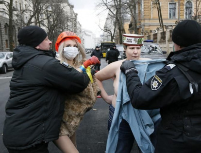 Policías detienen a activistas 'topless' del grupo de derechos de la mujer Femen, que protagonizaron una manifestación contra el presidente ucraniano Petro Poroshenko mientras se conmemoraba el Día de la Dignidad y la Libertad cerca de la sede de la administración presidencial en Kiev, Ucrania, el 21 de noviembre.